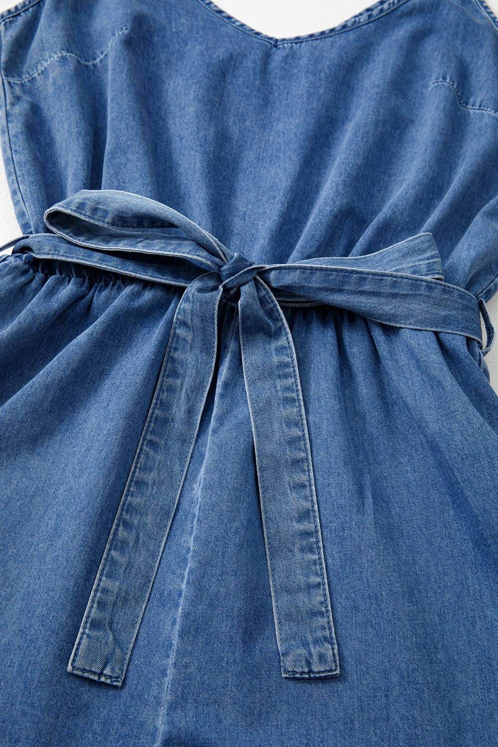 Light wash denim ruffle-leg belted romper with sleeveless design – casual summer jumpsuit for women.