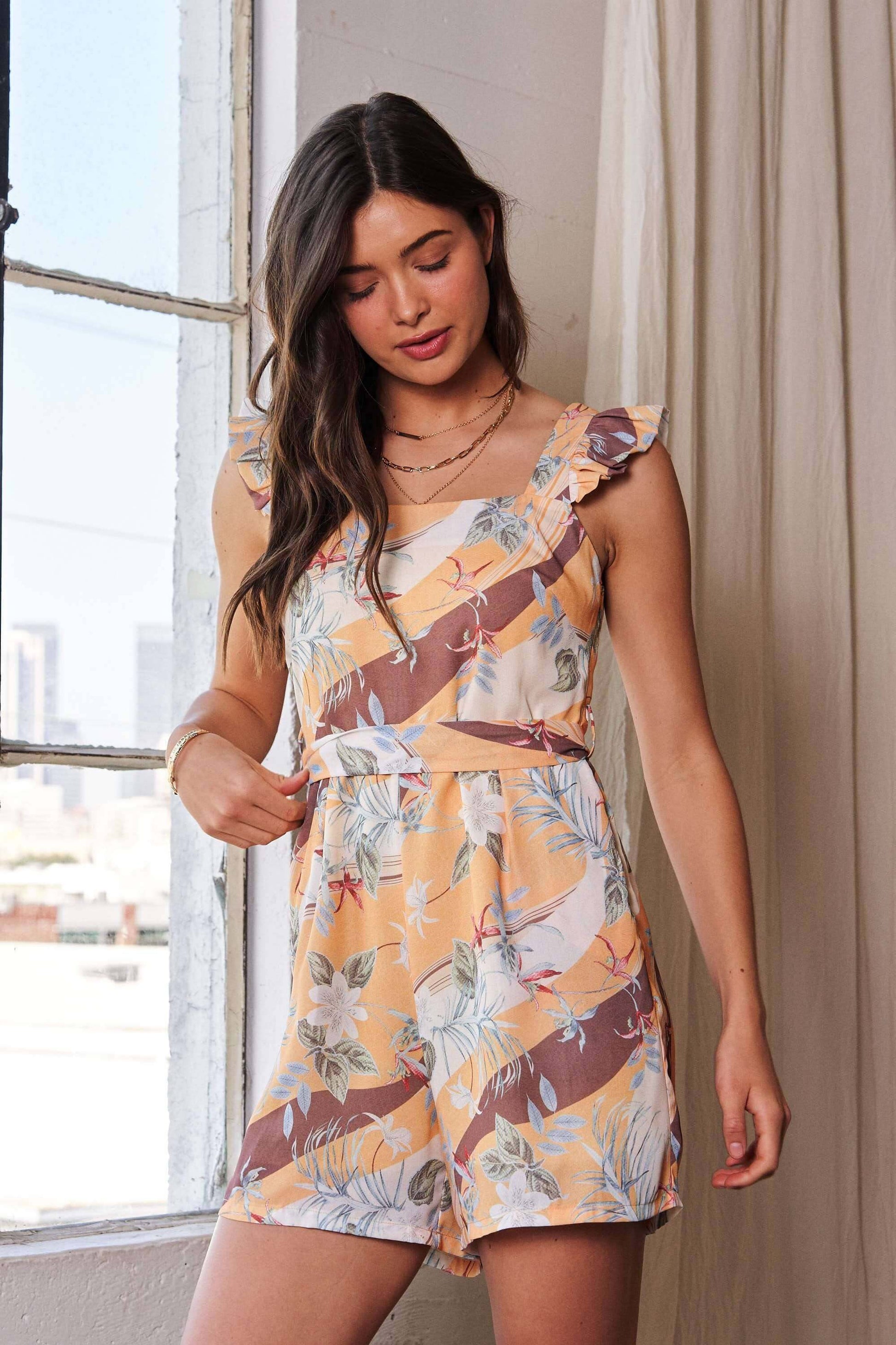 Yellow and mauve floral print romper with square neckline and ruffle shoulder detail – lightweight and playful one-piece outfit