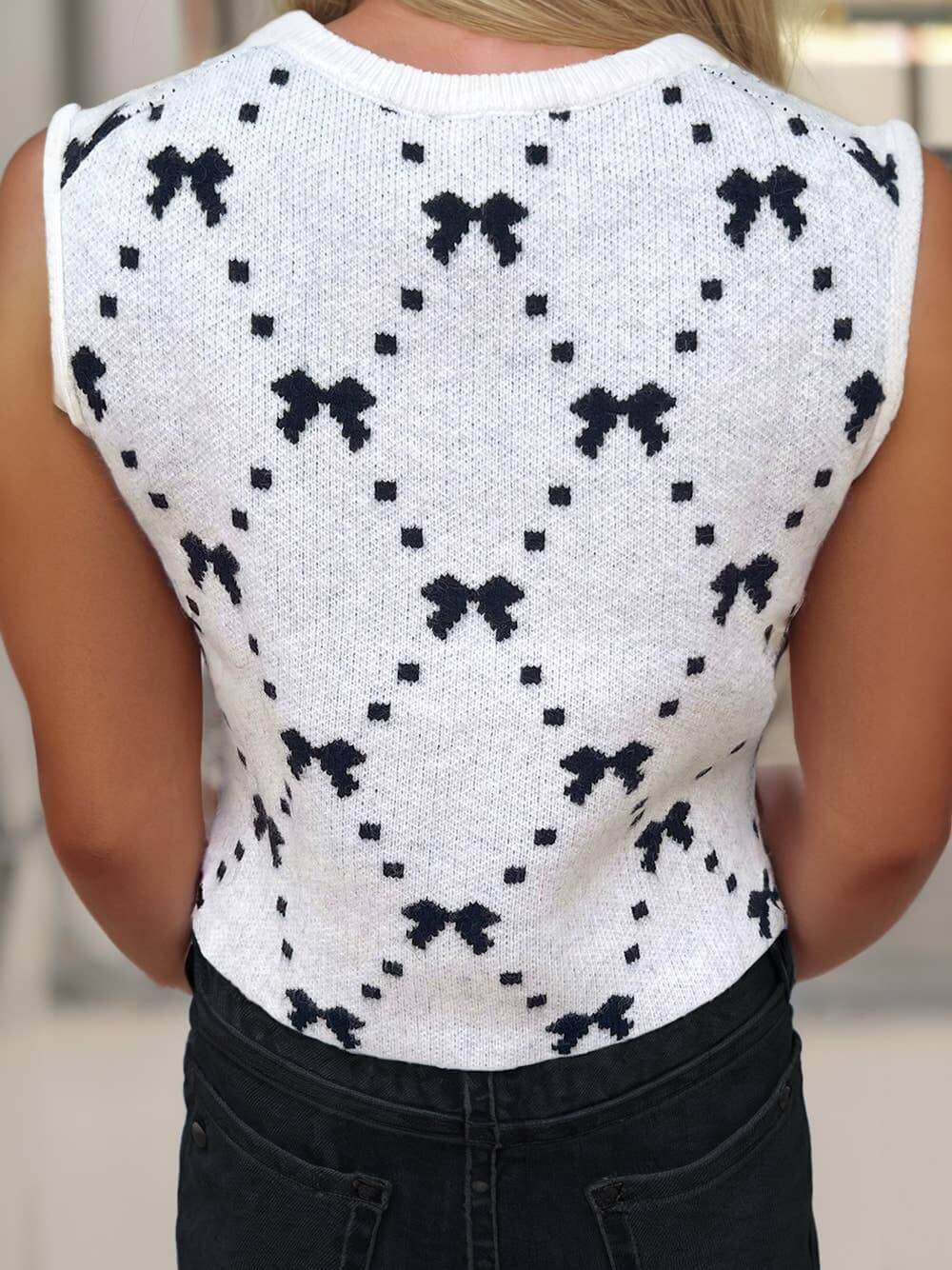 Ivory knit cropped sweater vest with bow pattern and side button details – sleeveless trendy layering top