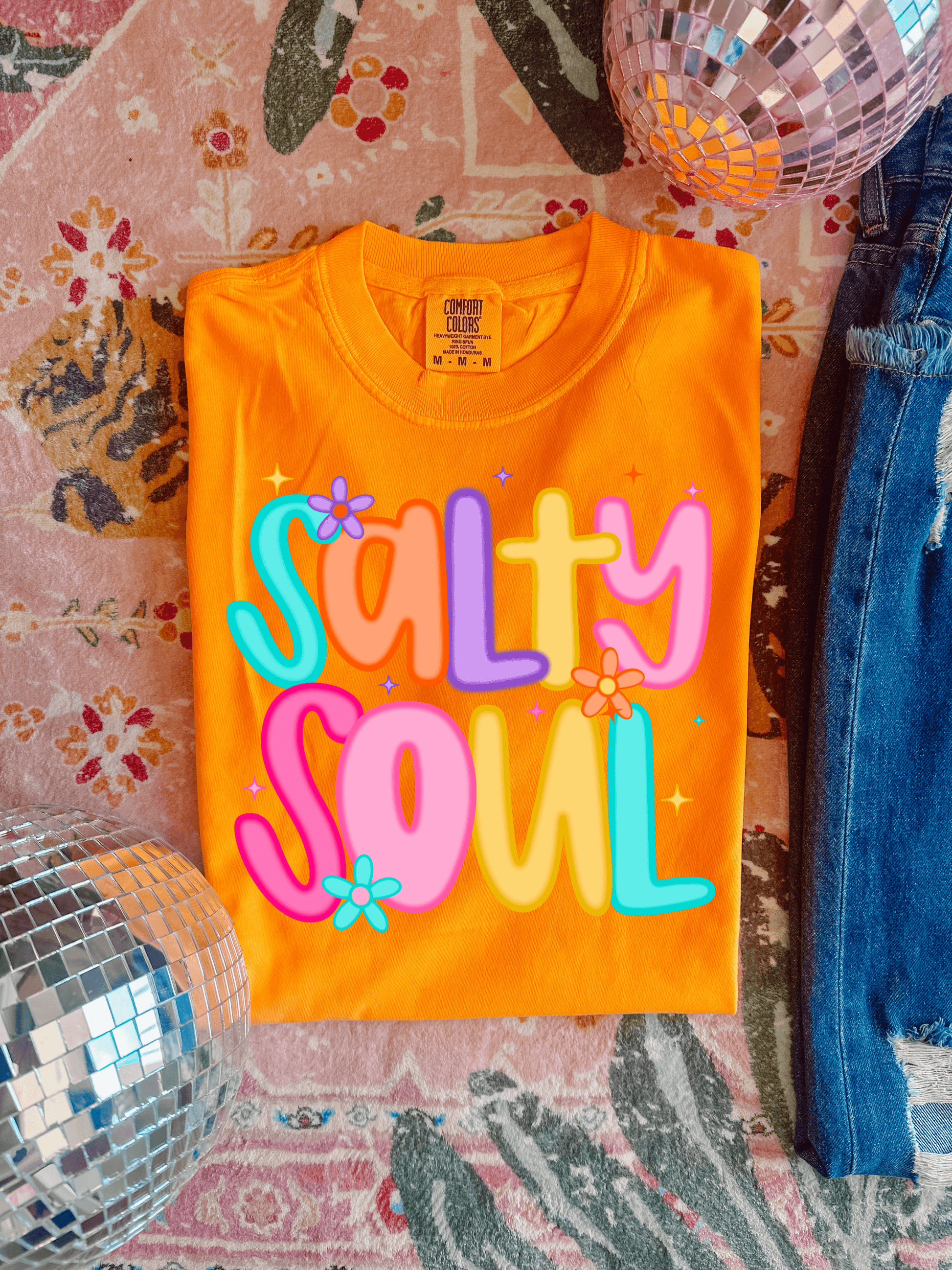 Orange t-shirt with 'Salty Soul' text on a patterned surface