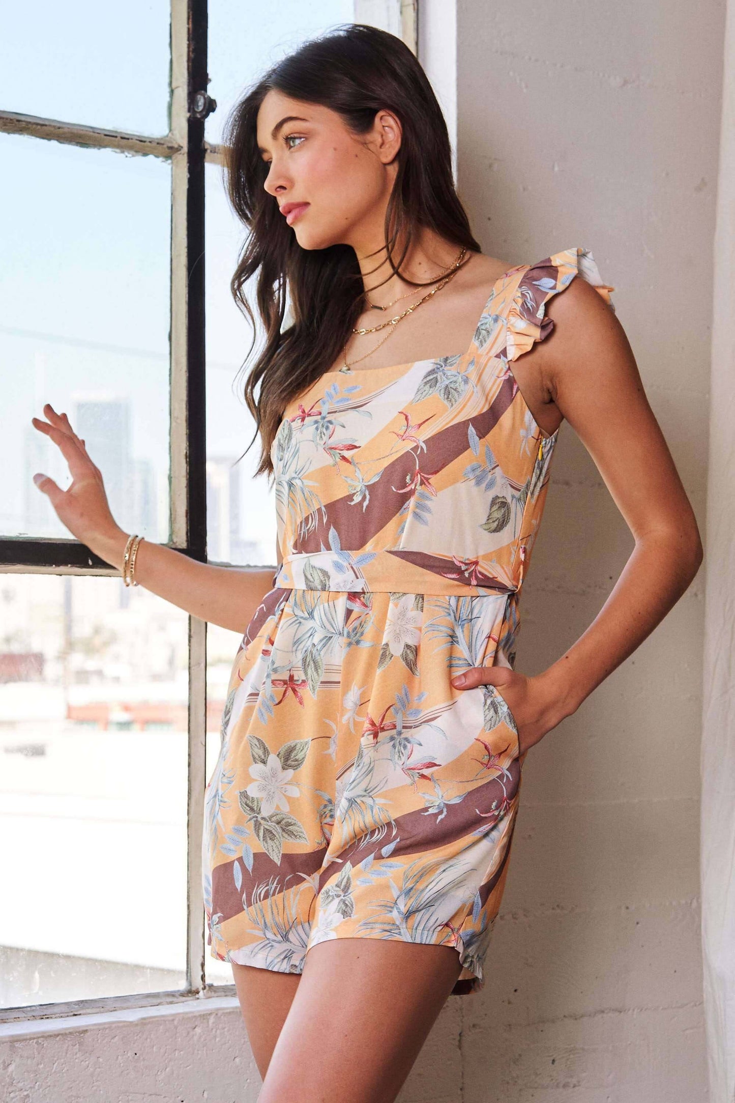 Yellow and mauve floral print romper with square neckline and ruffle shoulder detail – lightweight and playful one-piece outfit