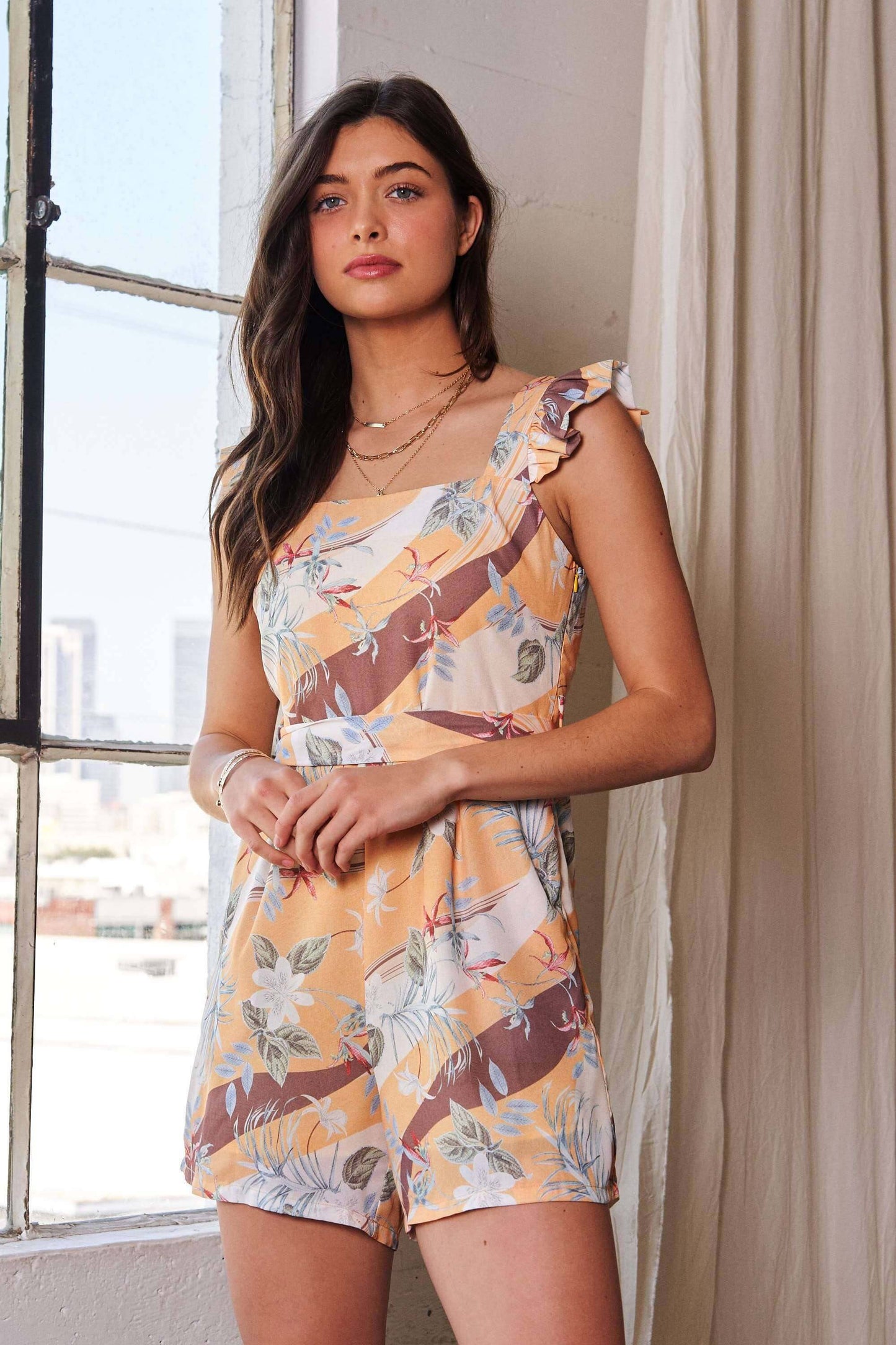 Yellow and mauve floral print romper with square neckline and ruffle shoulder detail – lightweight and playful one-piece outfit