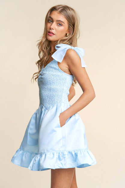 Light blue smocked mini dress with tiered ruffle hem and bow tie straps – sweet and elegant spring look