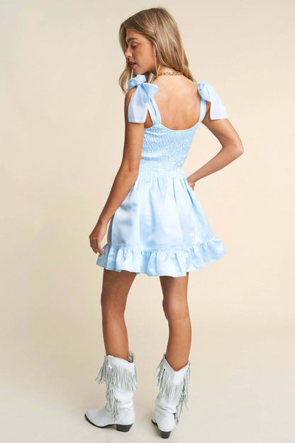 Light blue smocked mini dress with tiered ruffle hem and bow tie straps – sweet and elegant spring look